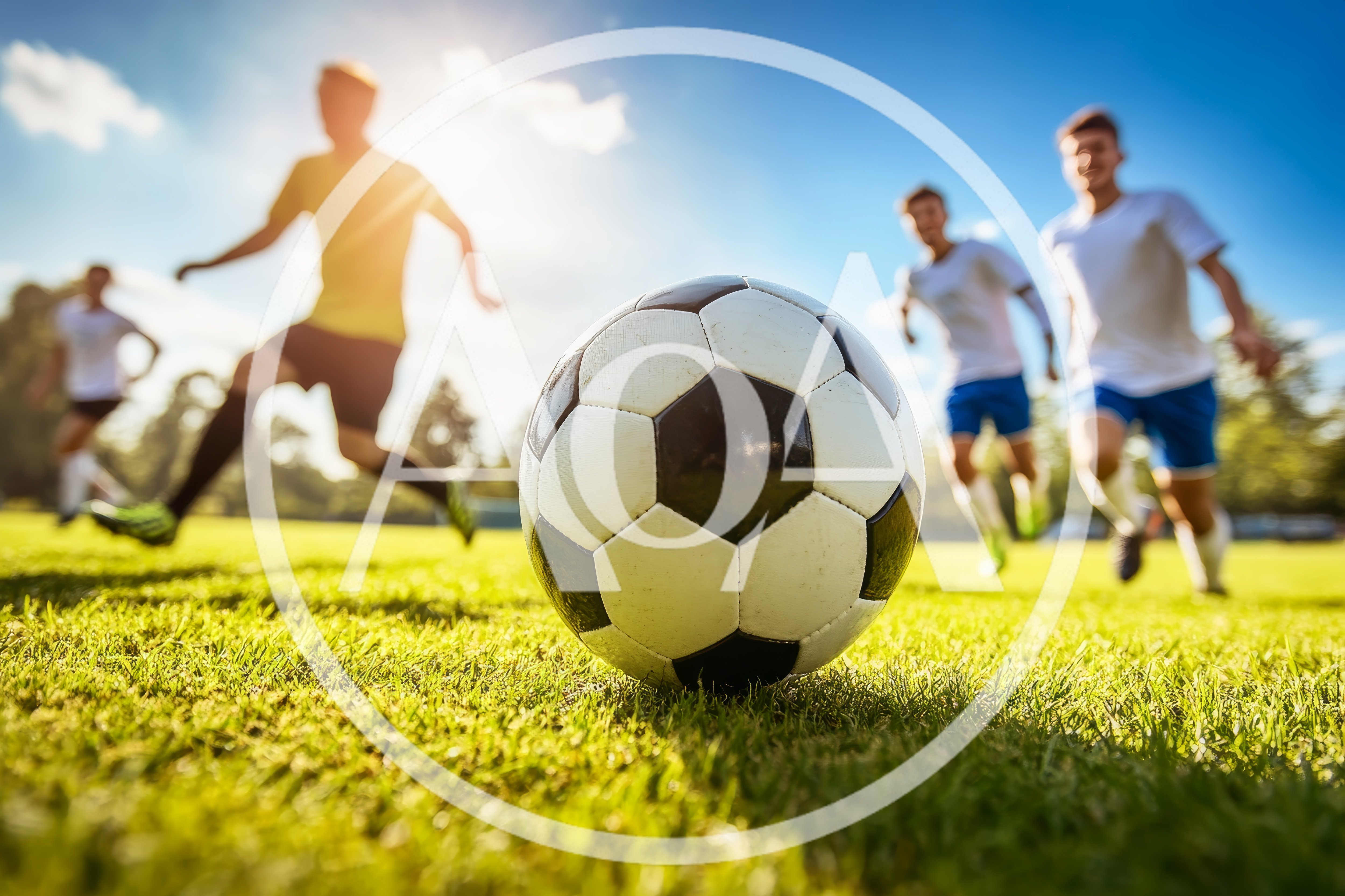 Soccer Players Running Toward Ball on Sunny Field