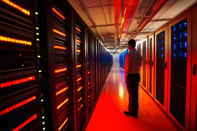 IT Professional Inspecting Server Racks in Data Center