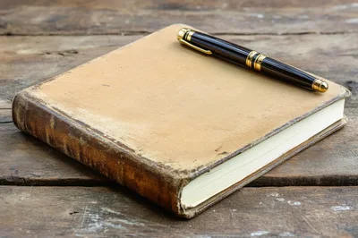 Vintage Leather Journal With Fountain Pen On Wooden Table