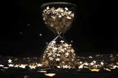 Gold Star Confetti Inside A Glass Hourglass