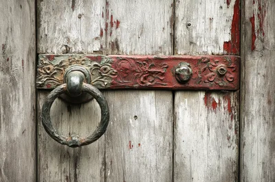 Antique Metal Door Knocker On Weathered Wooden Door