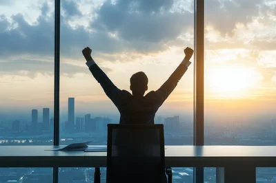 Businessman Celebrating Success In High Rise Office