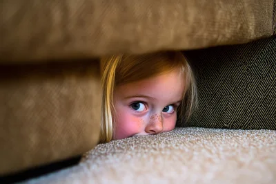 Kids playing hide and seek in a cozy house.