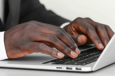 Close Up Of African American Businessman Typing On Laptop