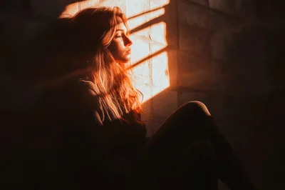 Young Woman Sitting Alone In Warm Sunlight