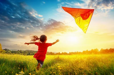 Little Girl Running Through Meadow Flying A Kite