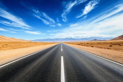 Empty Asphalt Road Through Vast Desert Landscape