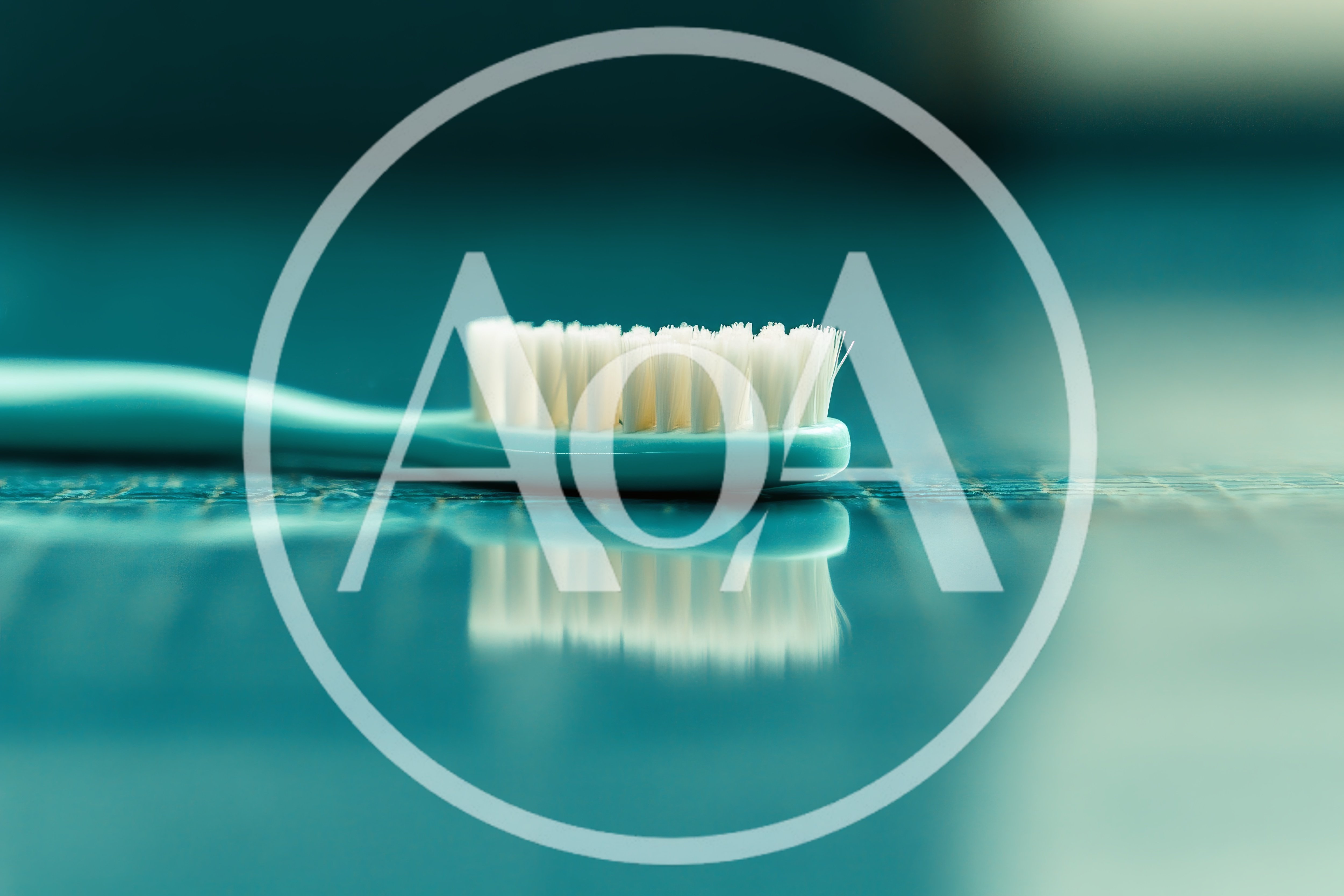 Teal Toothbrush Resting On A Reflective Surface