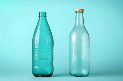 Two Empty Glass Bottles On A Light Blue Background