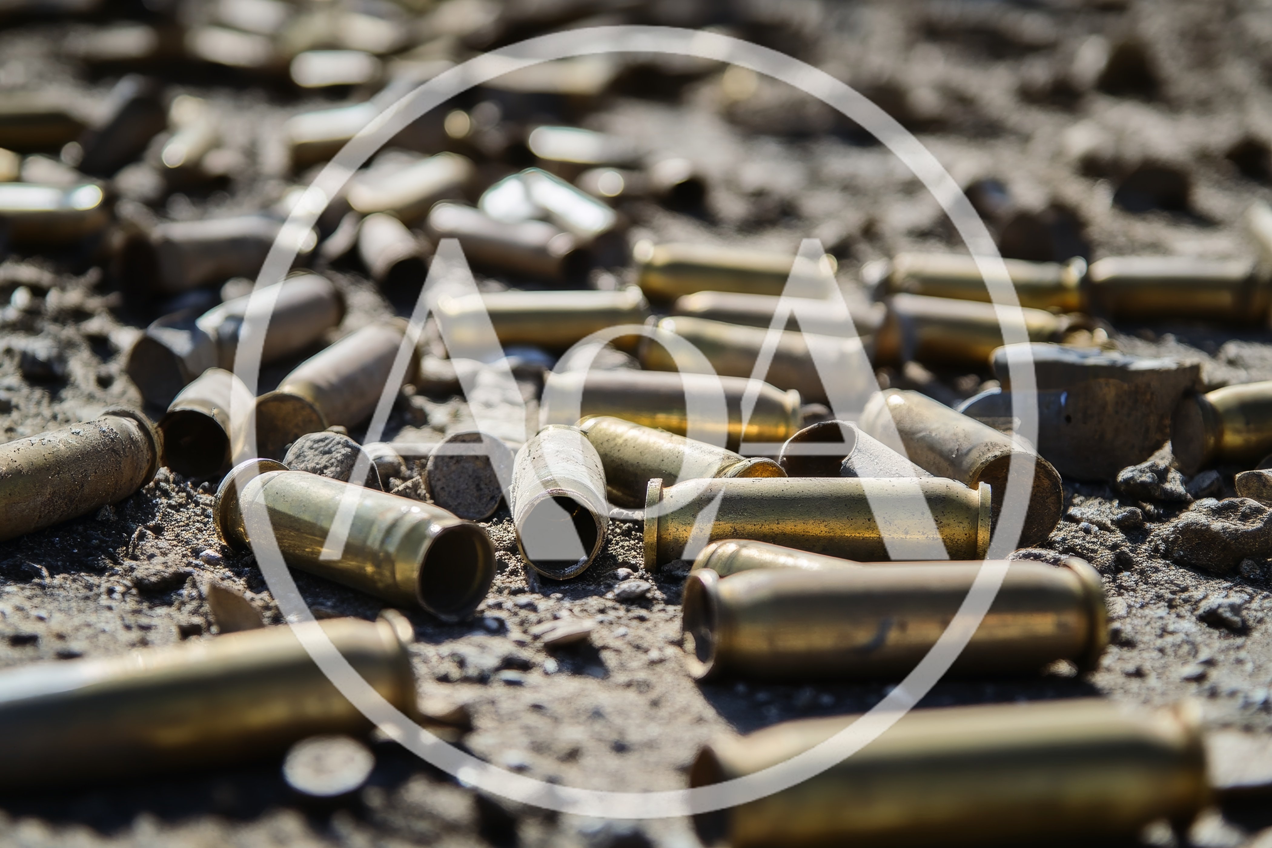 Spent Brass Bullet Casings Scattered On Dirt Ground