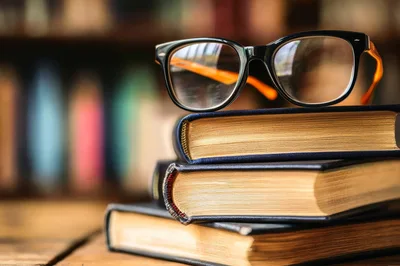 Stack Of Old Books With Reading Glasses