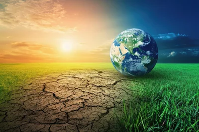 Conceptual Earth Globe Between Cracked Earth and Green Grass