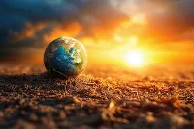 Miniature Earth Globe Resting On Dry Cracked Earth