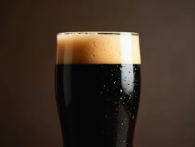 Glass Of Dark Stout Beer With Creamy Foam