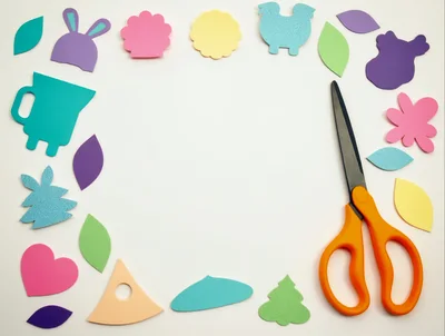 Craft Supplies Arranged Around Scissors on White Background