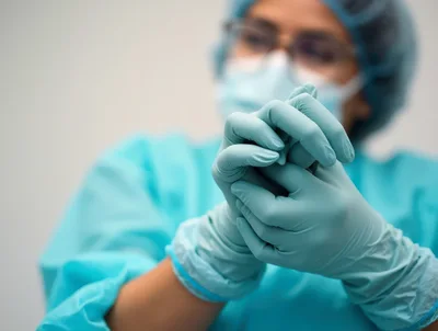 Healthcare Professional Putting On Sterile Surgical Gloves