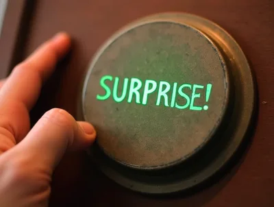 Hand Pressing A Glowing Green Surprise Button