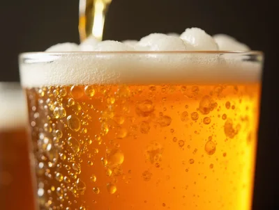 Golden Beer Pouring Into A Glass With Bubbles