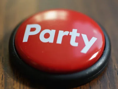Red Party Button On A Wooden Surface