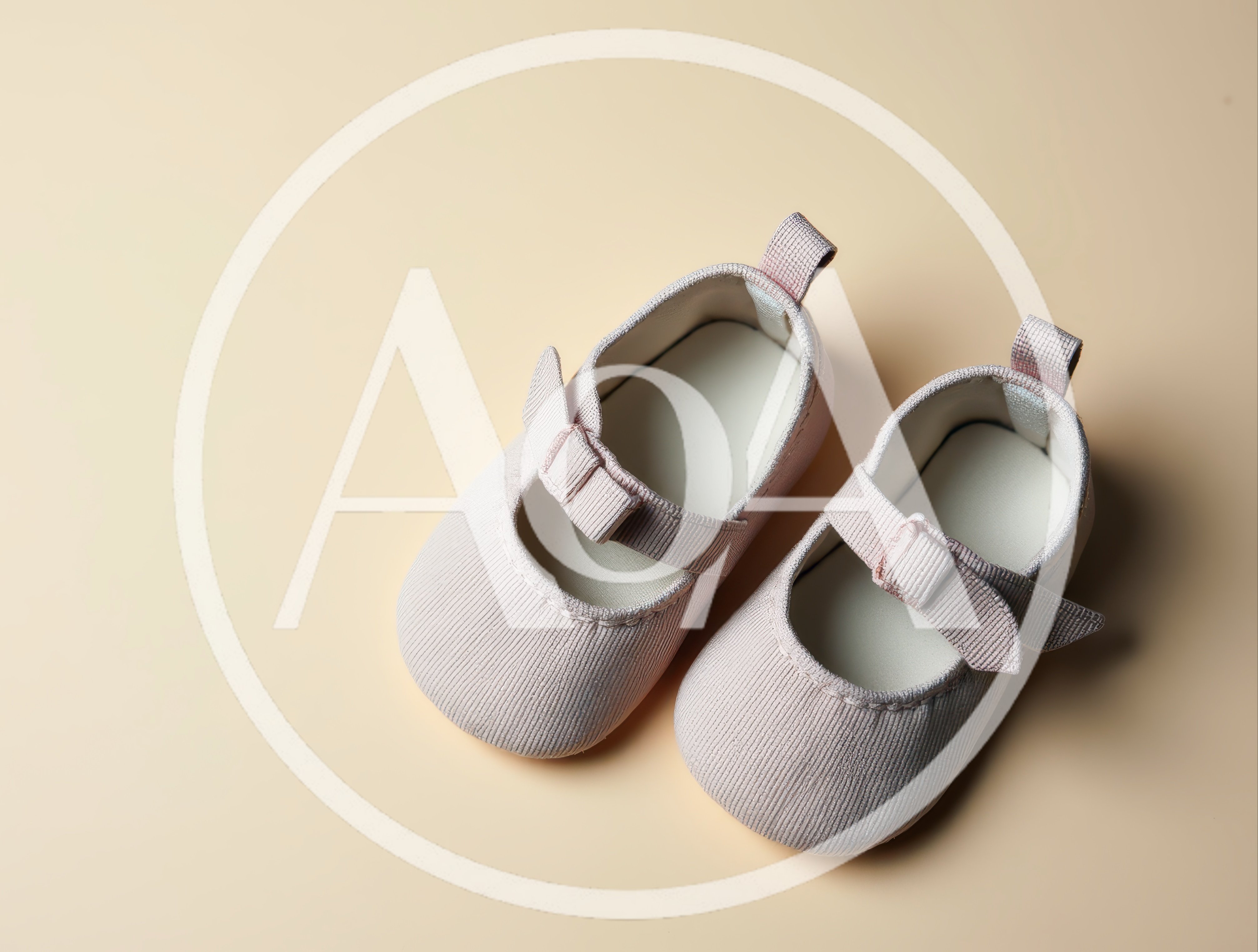 Pair of Pink Baby Shoes on Beige Background