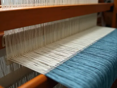 Close Up Of A Loom Weaving Blue And White Fabric