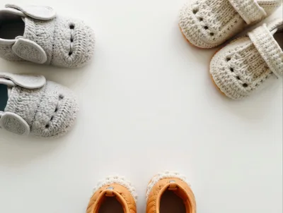 Three Pairs Of Baby Shoes On White Background