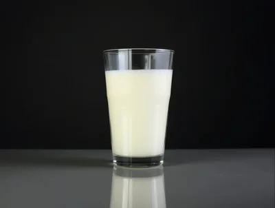 Glass Of Fresh Milk On A Reflective Surface