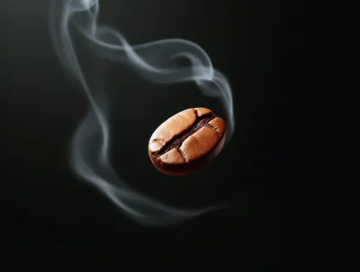 Single Roasted Coffee Bean With Wisps Of Smoke