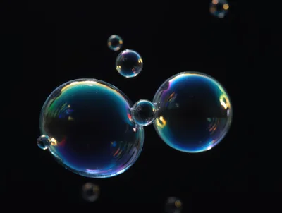 Floating Iridescent Soap Bubbles Against Black Background