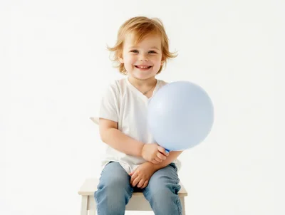 Happy Toddler Holding A Light Blue Balloon
