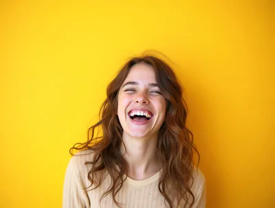 Young Woman Laughing Joyfully Against Yellow Background
