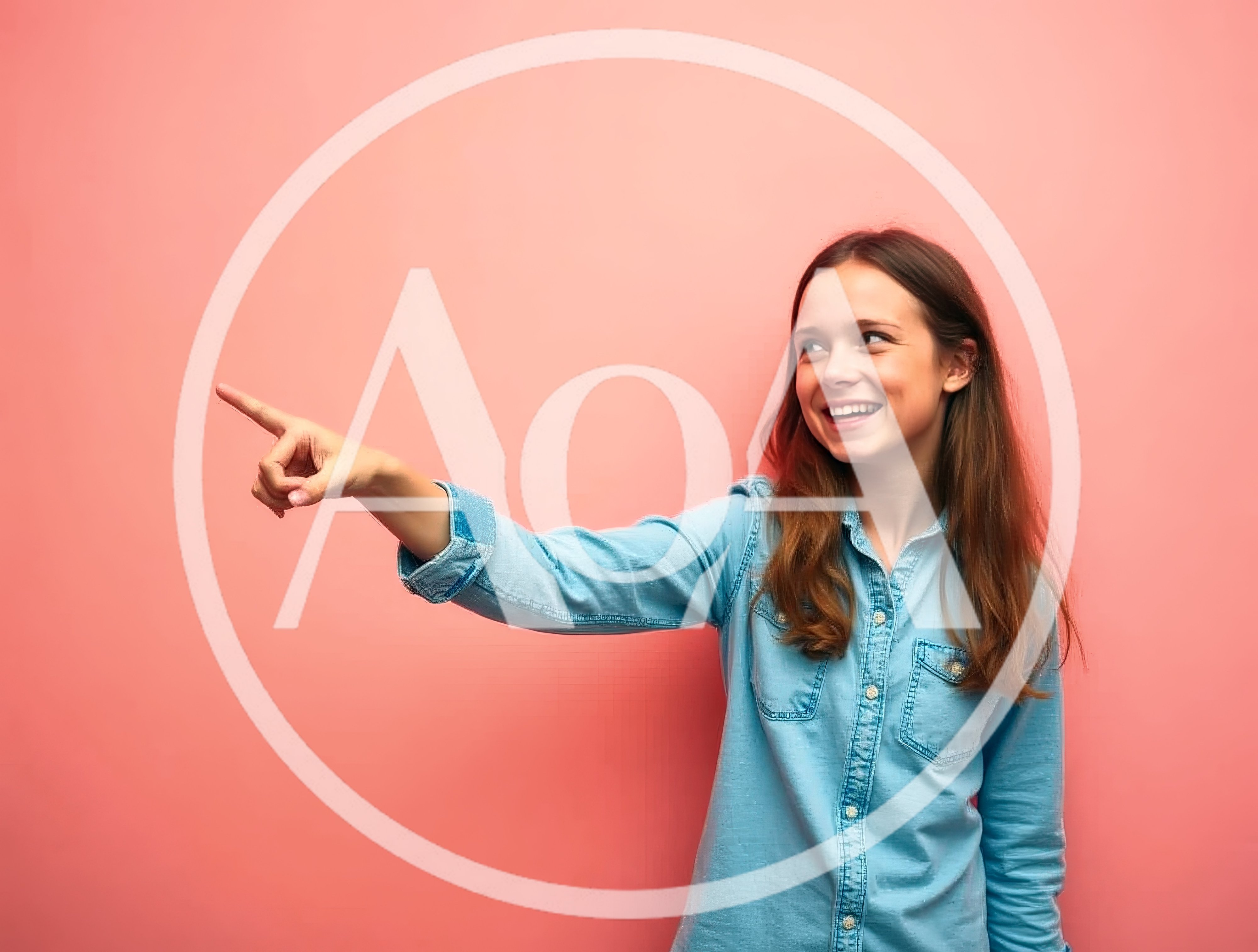 Young Girl Pointing To The Side Against Pink Background