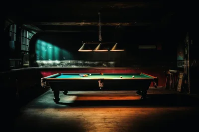 Billiard Table Under Hanging Lights In Dimly Lit Room
