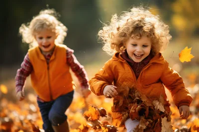 Two Happy Children Playing In Autumn Leaves