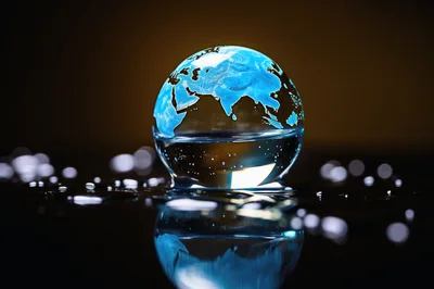 Glowing Glass Globe Resting On A Reflective Surface