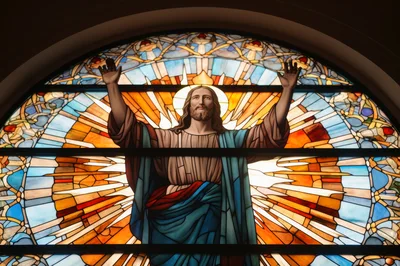 Stained Glass Window Depicting Jesus Christ With Raised Arms