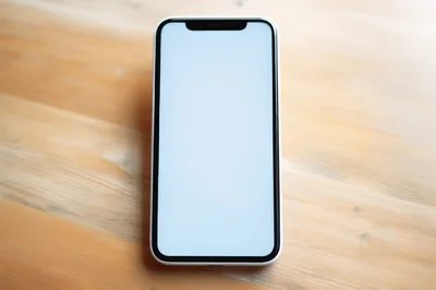 Modern Smartphone With Blank Screen On Wooden Table