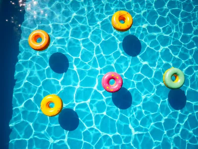 Colorful Inflatable Pool Rings Floating In Swimming Pool