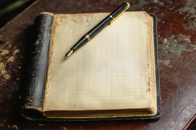 Vintage Fountain Pen Resting On An Open Grid Notebook
