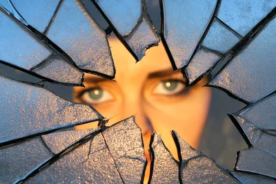 Woman Looking Through Shattered Glass Pane