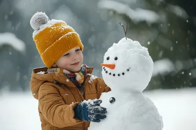 Young Boy Building A Snowman In Winter