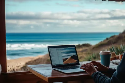 Person Working On Laptop Overlooking The Ocean