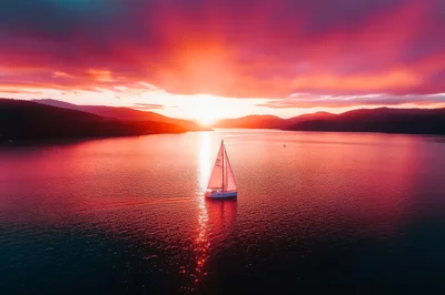 Sailboat Cruising On A Calm Lake At Sunset