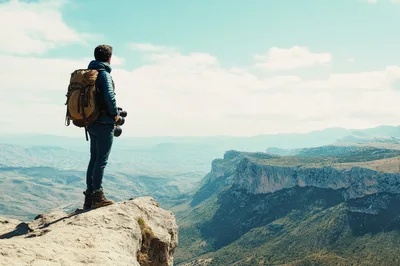 Photographer Standing On A Mountain Cliff Edge