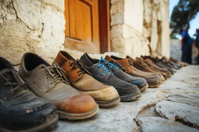 Row Of Worn Leather Shoes On Stone Pavement