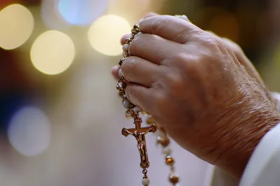 Elderly Hands Holding A Rosary In Prayer