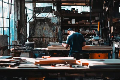 Carpenter Working With Plywood In A Woodworking Workshop