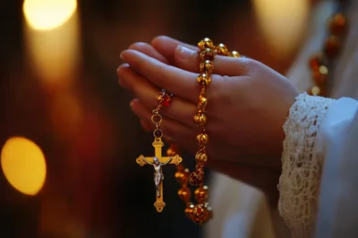 Hands Holding Golden Rosary Beads In Prayer