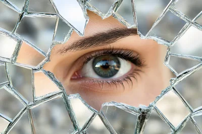 Close Up Of A Human Eye Through Broken Glass