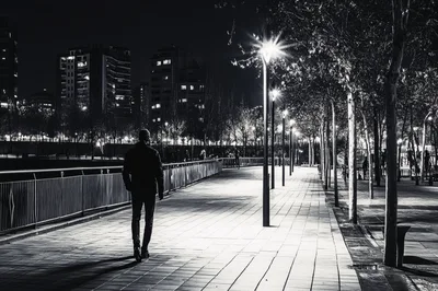 Man Walking Alone on a City Promenade at Night